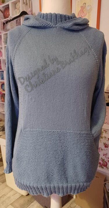 Gestrickter hellblauer Kapuzenpullover auf Schneiderpuppe mit Kängurutasche