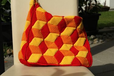 Gehäkelte Umhängetasche mit dreidimensional wirkendem Würfelmuster in Rot, Orange und Gelb