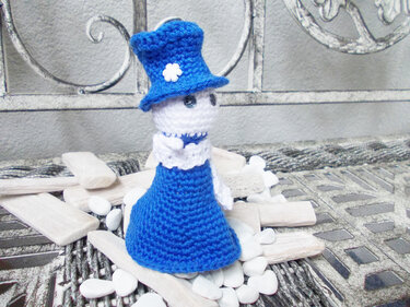 Amigurumi-Puppe in Blau mit Hut und weißer Blüte