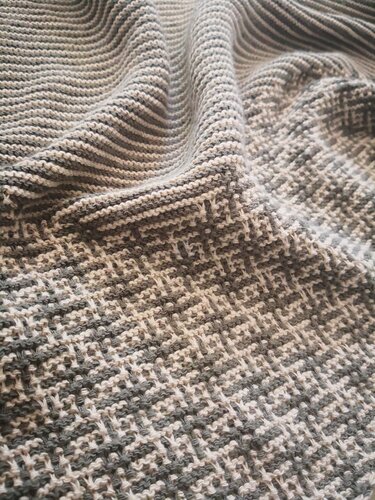 Detailaufnahme eines Dreieckstuchs mit abwechselnden Rippenstreifen und kleinem Gitter‑ähnlichem Strukturmuster