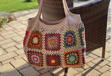 Gehäkelte Shopper-Tasche aus neun bunten Granny-Squares mit beigem Abschluss und Henkeln