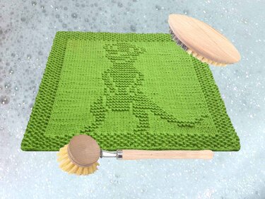 Gestricktes grünes Spültuch mit Känguru‑Relief und Holzbürsten