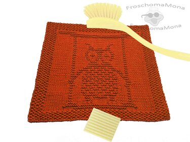 Rostrotes gestricktes Spültuch mit eingestrickter Eule, Spülbürste und Seife auf weißem Hintergrund