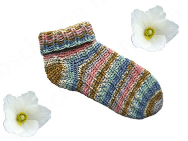 Handgehäkelte Socke mit bunten Streifen und umgeschlagenem Rippenbündchen, dekoriert mit zwei weißen Blüten auf hellem Hintergrund.