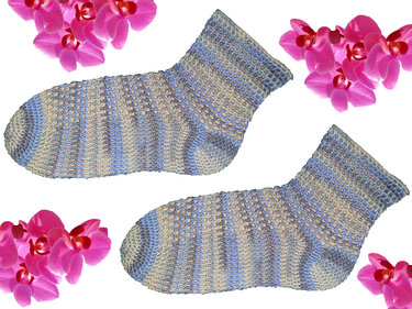 Gehäkelte Damensocken in Blau, Grau und Beige mit offenem Lochmuster, umgeben von pinken Orchideen auf weißem Hintergrund.