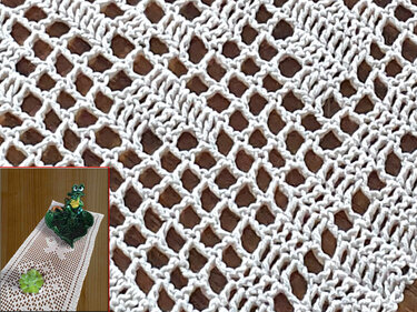 Nahaufnahme eines weißen Häkelmusters mit offenen Maschen und diagonalen Reihen