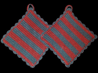 Zwei quadratische gehäkelte Topflappen mit roten und blauen Streifen und Muschelkante
