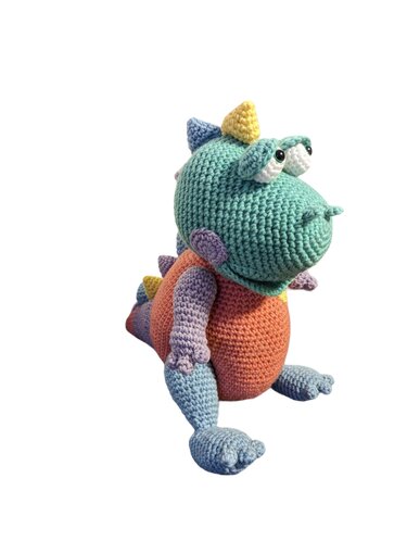 Handgefertigter sitzender Amigurumi-Dino mit türkisfarbenem Kopf, orangefarbenem Bauch und hellblauen Beinen auf neutralem Hintergrund.