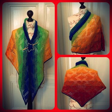 Handgehäkeltes Dreieckstuch mit Farbverlauf und Lochmuster, befestigt mit Holzsternnadel auf Schneiderpuppe