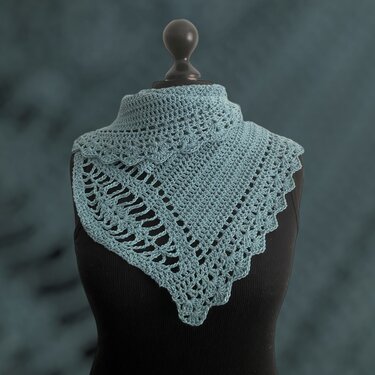 Blaugrünes gehäkeltes Dreieckstuch auf schwarzer Schneiderpuppe