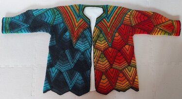 Gestrickte Damenjacke, flach liegend, mit geometrischem V-Muster in Blau-Grün und Rot-Orange