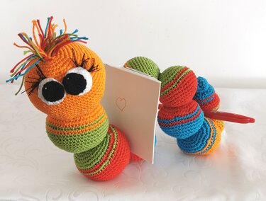 Gehäkelte Raupe Amigurumi mit Notiz und Stift, bunten Kugelsegmenten