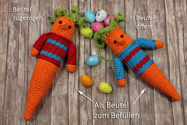 Zwei gehäkelte Karottenbeutel in Orange mit gestreiften Oberteilen und grünen Blättern, eine offen, eine zugezogen