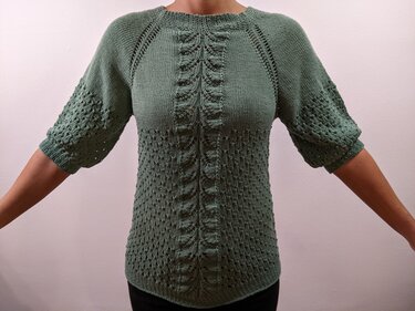 Grüner gestrickter Damenpullover mit zentralem Zopfmuster, Ajourmuster und halblangen Raglanärmeln