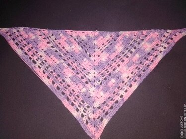 Gehäkeltes dreieckiges Tuch in rosa und lila Pastell mit Ajour‑ und Lochmuster auf dunklem Hintergrund