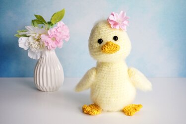 Gelbes Amigurumi-Entchen mit geformtem Schnabel und gelben F
00FC
00DFen, frontal stehend