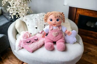 Gehäkelte Puppe mit rosa Latzhose, Schlafmaske und Wolkenkissen als Accessoires