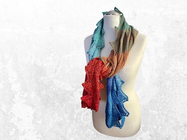 Mehrfarbiger gestrickter Schal in Türkis, Rostrot und Blau mit Lochmuster an einer Schneiderpuppe