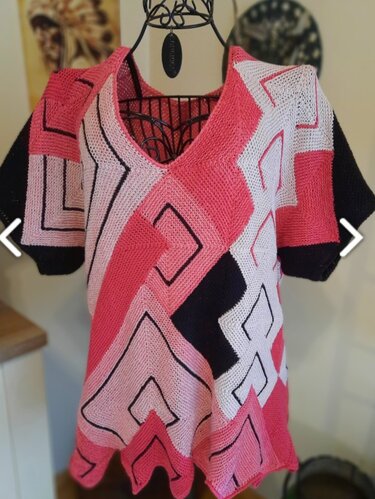 Gestricktes Damen‑Shirt in Pink, Weiß und Schwarz mit geometrischem Muster und V‑Ausschnitt auf Schneiderpuppe