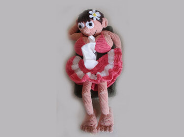 Liegende gehäkelte Amigurumi-Puppe in Pink als Taschentuchspender