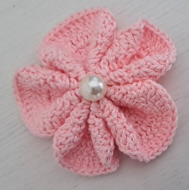 Pastellrosa Häkelblüte mit Perlenzentrum