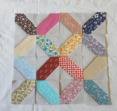 Patchwork-Block mit diagonalen bunten Streifen auf hellem Grund