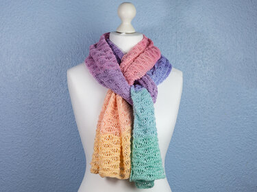 Pastellfarbener gestrickter Schal mit offenem Lochmuster an Schaufensterpuppe