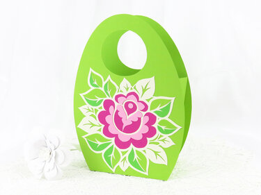 Ovale grüne Papiertasche mit rosa Blumenmotiv und rundem Griff