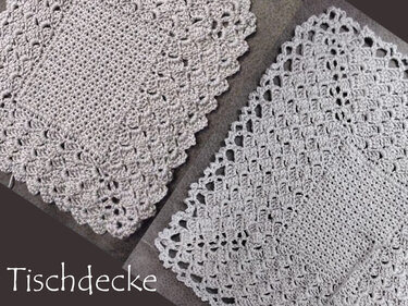Zwei hellgraue gehäkelte Deckchen mit Muschelmuster am Rand auf dunklem Untergrund