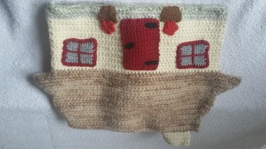 Gehäkeltes Hausmotiv in Beige und Creme mit roter Tür und zwei Fenstern