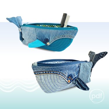 Two whale-shaped denim zipper pouches with tail and fin details; one pouch open showing pens inside