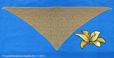 Beiges, gehäkeltes Dreieckstuch mit geometrischem Filetmuster auf blauem Hintergrund