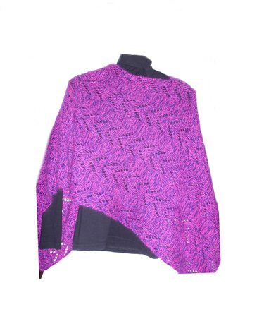 Asymmetrischer gestrickter Poncho in Magenta mit Zickzack-Lochmuster über dunklem Oberteil.