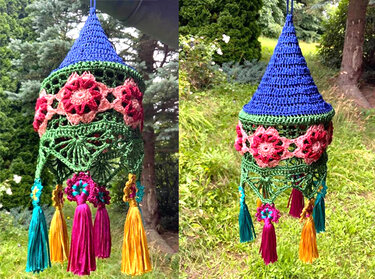 Bunter gehäkelter Lampion mit Blumenapplikationen und bunten Quasten vor grünem Gartenhintergrund