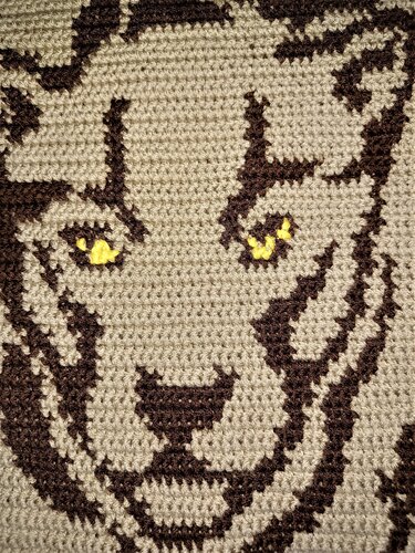 Gehäkeltes Pixelmuster eines Tigerkopfes in Beige und Braun mit gelben Augen