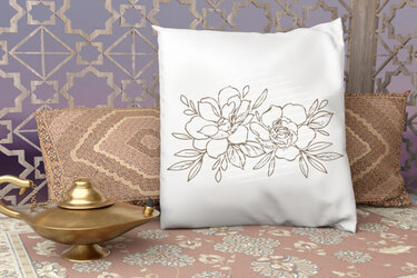 Weiße Kissenhülle mit floraler Linienzeichnung vor dekorativem geometrischem Hintergrund und weiteren Kissen