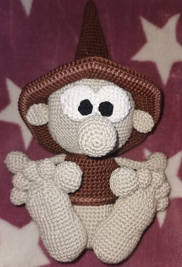 Gehäkelter Wichtel in Beige und Braun mit spitzem Hut, runder Nase und kontrastreichen Augen.