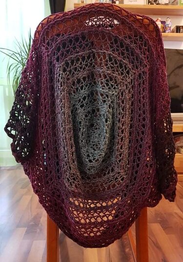 Gehäkelter Seelenwärmer in Bordeaux und Anthrazit mit Lochmuster, auf einer Stuhllehne drapiert