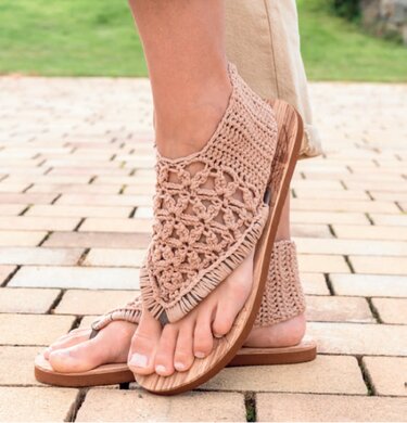 Beige gehäkelte Damen-Sandalen mit offener Zehenpartie, Fersenriemen und Holzsohle, an den Füßen getragen