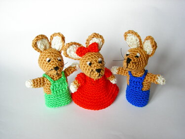 Drei gehäkelte Hasen-Fingerpuppen nebeneinander in grün, rot und blau