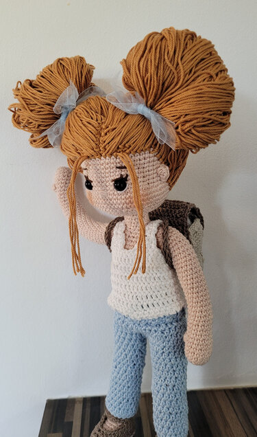 Gehäkelte Amigurumi-Puppe mit zwei großen Haarknoten, Schleifen und Rucksack