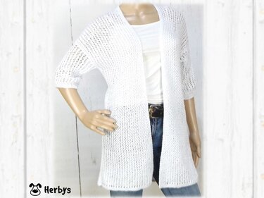 Mannequin trägt weiße, offene Strickjacke mit 3/4-Ärmeln und Ajourmuster