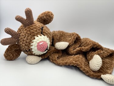 Brown crocheted reindeer lovey with plush textured blanket, pink snout and stitched eyes