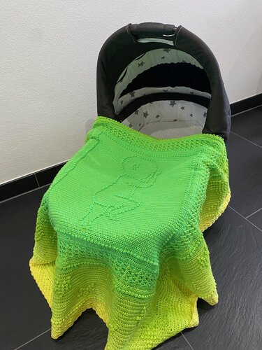 Kompakt gehäkelte Babyschalen‑Decke in grün‑gelbem Verlauf mit mittigem Reliefmuster