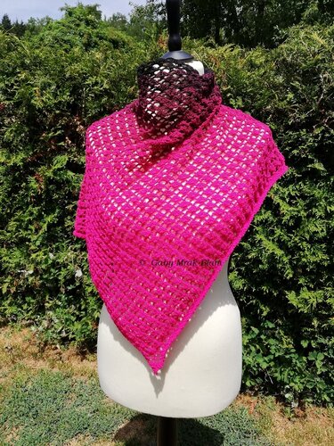 Bright fuchsia open-lace triangle crochet shawl on a mannequin with a dark gradient neck wrap