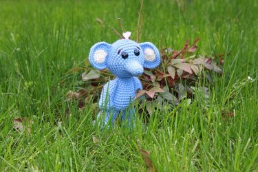 Gehäkelter blauer Amigurumi-Elefant mit großen Ohren im grünen Gras