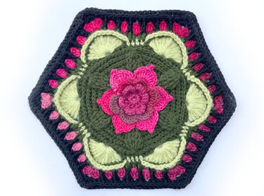 Gehäkeltes Hexagon-Motiv in Grün, Pink und Dunkelgrau mit plastischer Blume