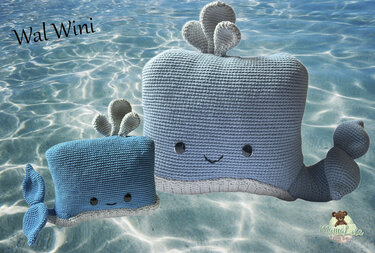 Zwei gehäkelte Wal‑Amigurumi, groß hellblau und klein dunkelblau, mit Augen, Mund, Schwanzflossen und Fontänen vor blauem Wasserhintergrund.