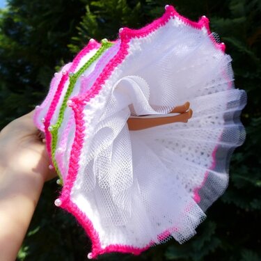Weißes gehäkeltes Puppenkleid mit Tüll, pinker Kante und Perlen, Ansicht von unten