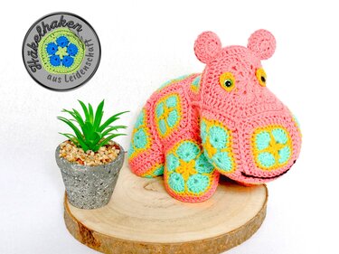 Crocheted amigurumi hippo made of African Flower granny motifs in pink, aqua and yellow